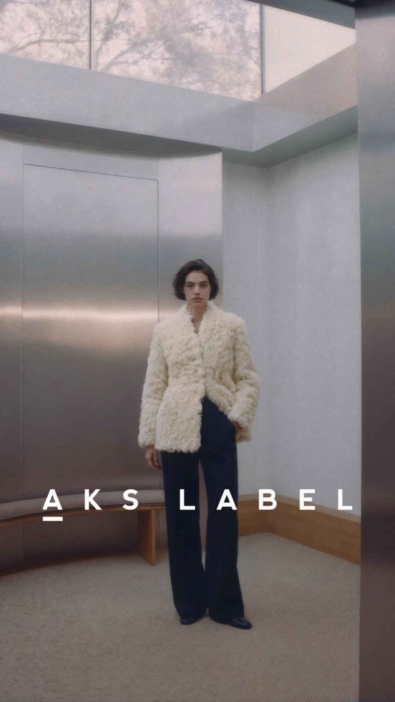 AKS Label model in a cream jacket in a minimalist interior