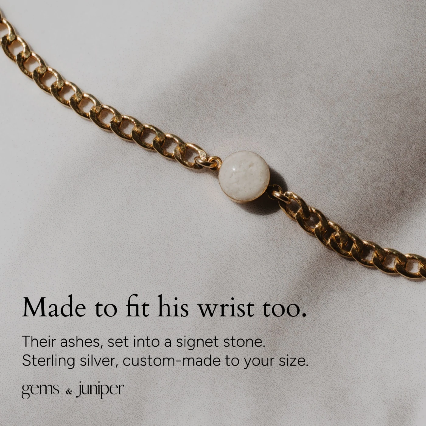 Close-up of a gold Gems & Juniper bracelet on a pale surface
