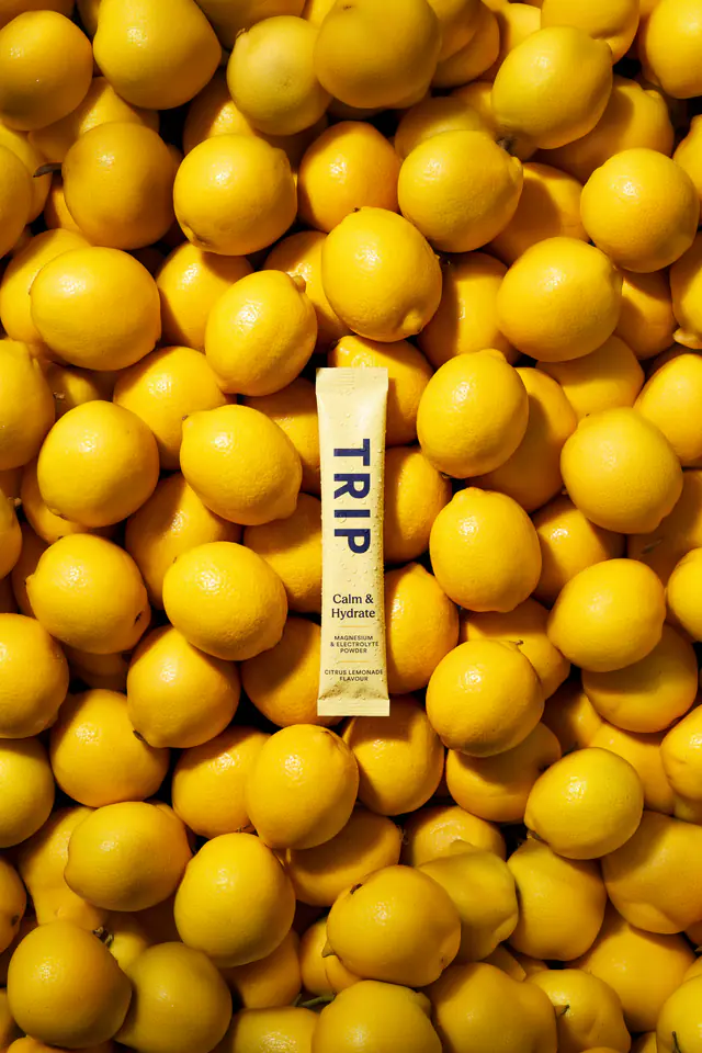 A TRIP Calm & Hydrate sachet on a bed of lemons.