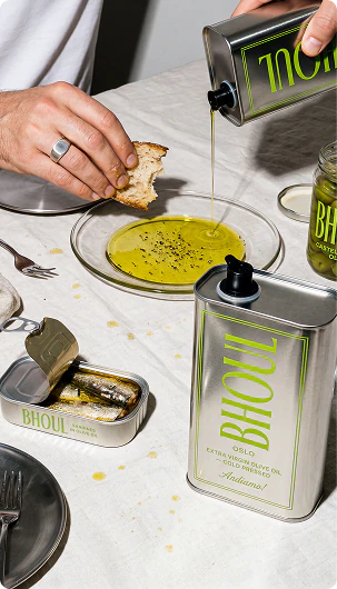 Bhouli cans and glassware arranged on a table with food.