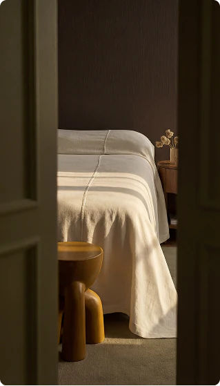 Quiet bedroom interior seen through a dark doorway.