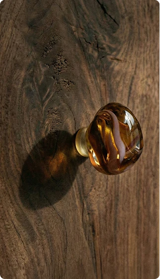 Amber glass object casting a circular shadow on dark wood.
