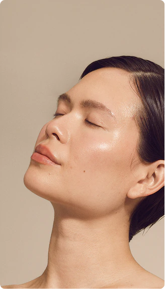 Profile beauty portrait with eyes closed against a warm neutral background.