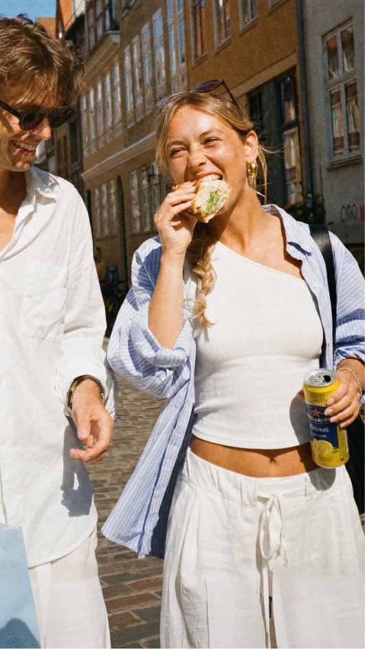 Friends eating takeaway food together on a city street.