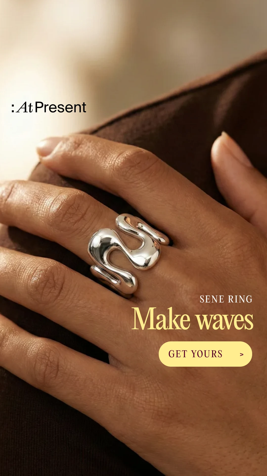 At Present Sene Ring in polished silver, photographed on a hand in warm light.