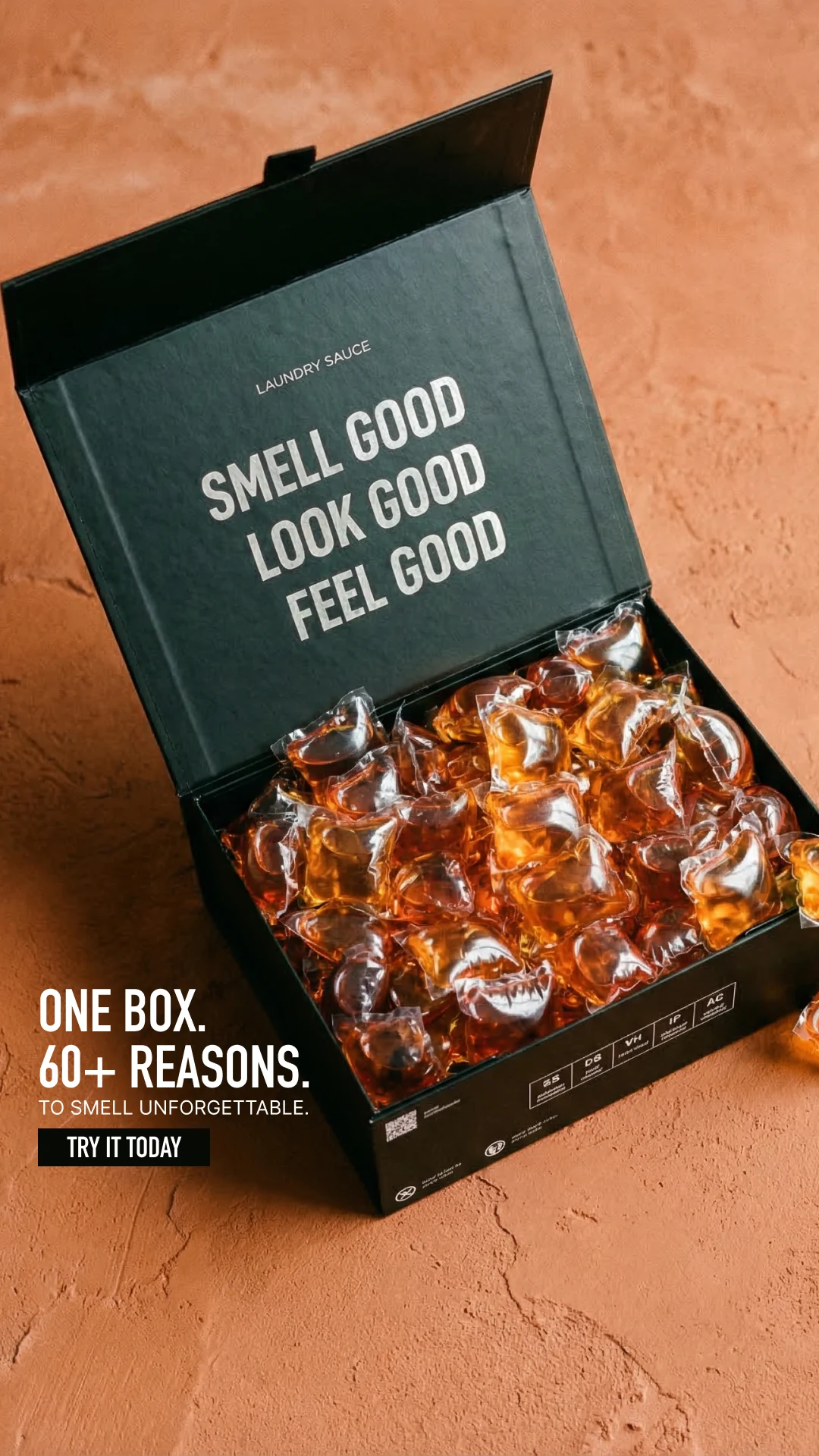 An open Laundry Sauce box filled with amber pods on a warm orange surface.